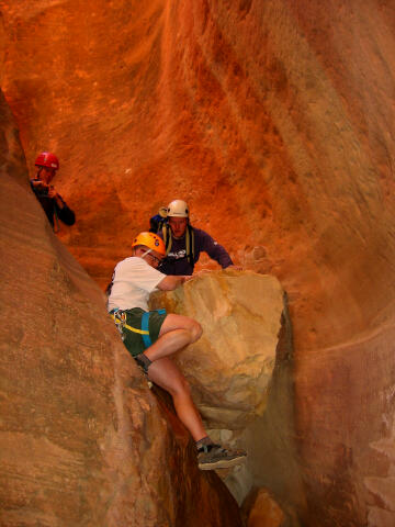 Hank Moon downclimbs while Sam and Jason watch.